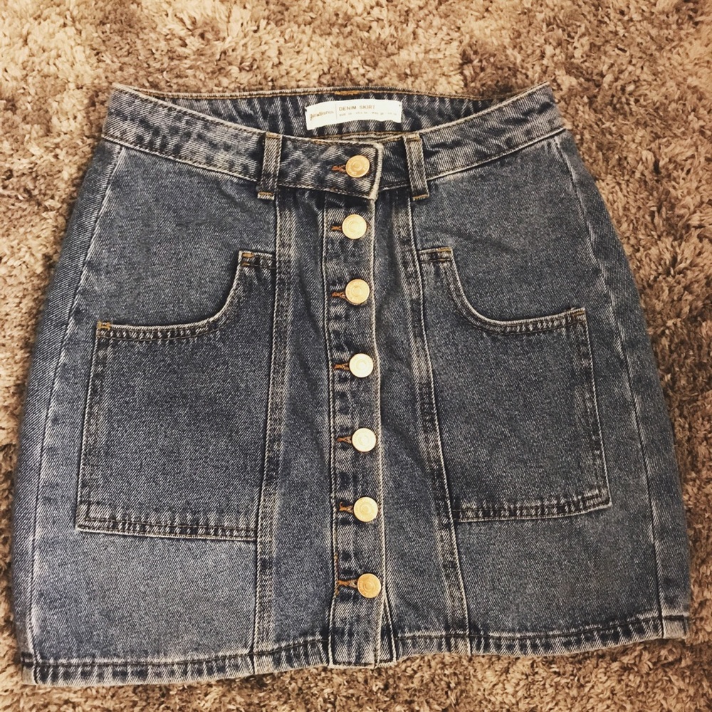 This is a jean skirt with gold buttons.